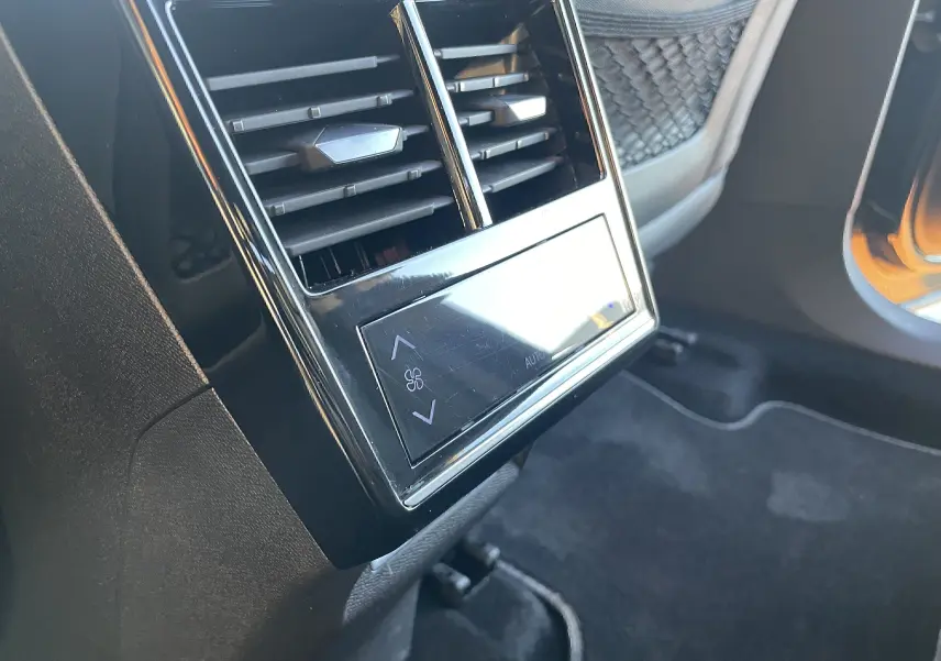 Détail des bouches d'aération arrière avec commandes de climatisation tactile dans un DS7 2024 noir Perla Nera.