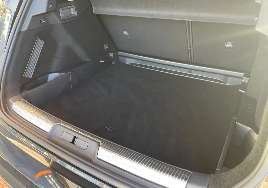 Coffre ouvert vu de l'arrière d'un DS7 noir Perla Nera 2024, montrant un espace de chargement propre et bien fini.