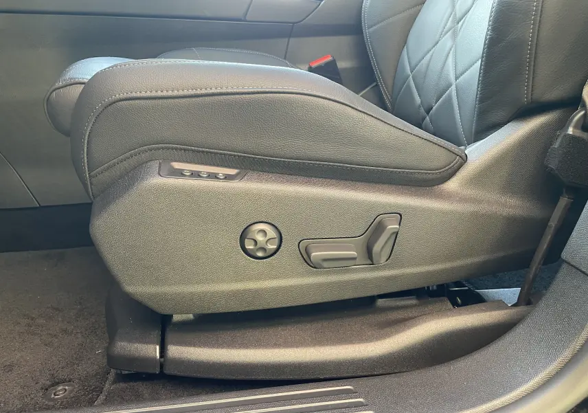 Gros plan sur les commandes de réglage électrique du siège avant gauche en cuir noir du DS7 2024.