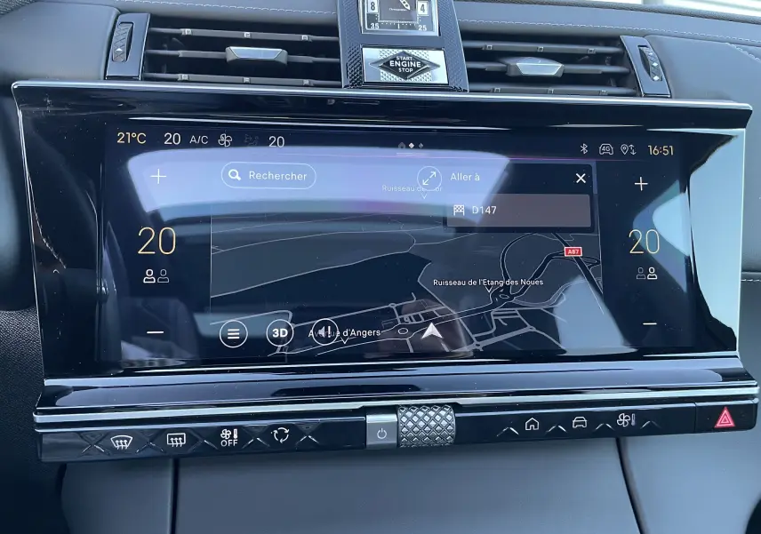 Écran tactile central du DS7 2024 noir Perla Nera affichant la navigation et la climatisation à 20°C, avec horloge analogique.