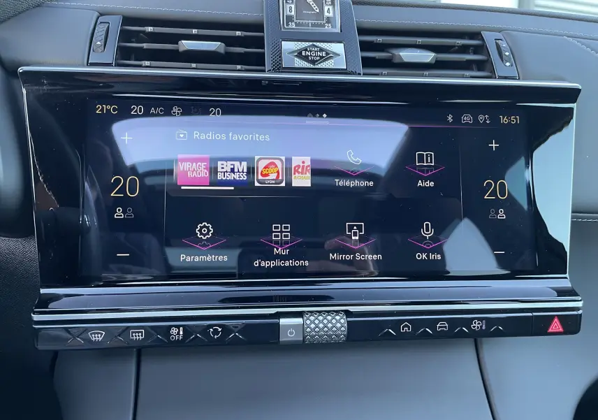 Vue rapprochée du tableau de bord du DS7 2024 noir Perla Nera, mettant en avant l'écran tactile central et l'horloge analogique.