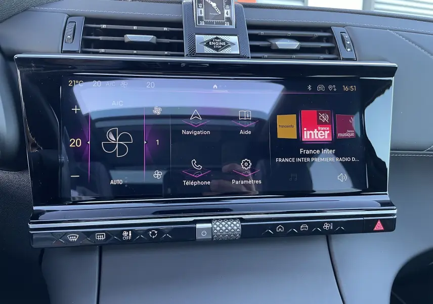 Écran tactile central du tableau de bord du DS7 2024 noir Perla Nera, affichant la climatisation et la radio France Inter.