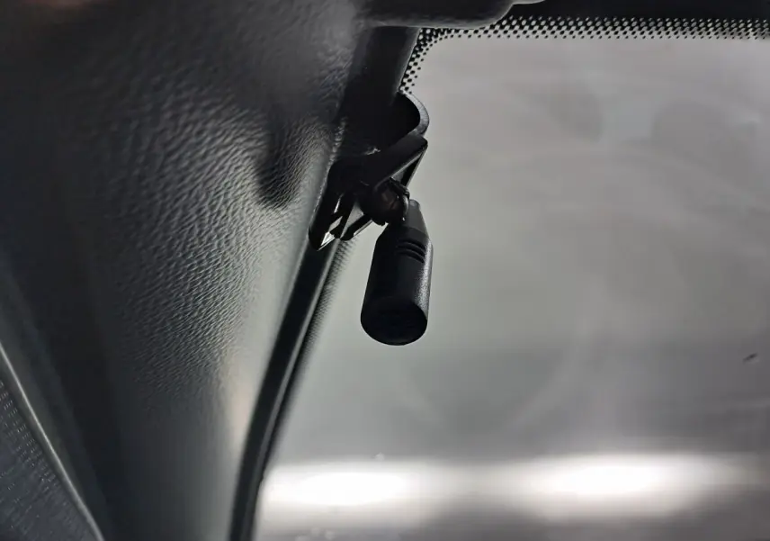 Gros plan sur la caméra fixée au plafond intérieur côté conducteur d'une Aixam MINAUTO E chic verte 2025.