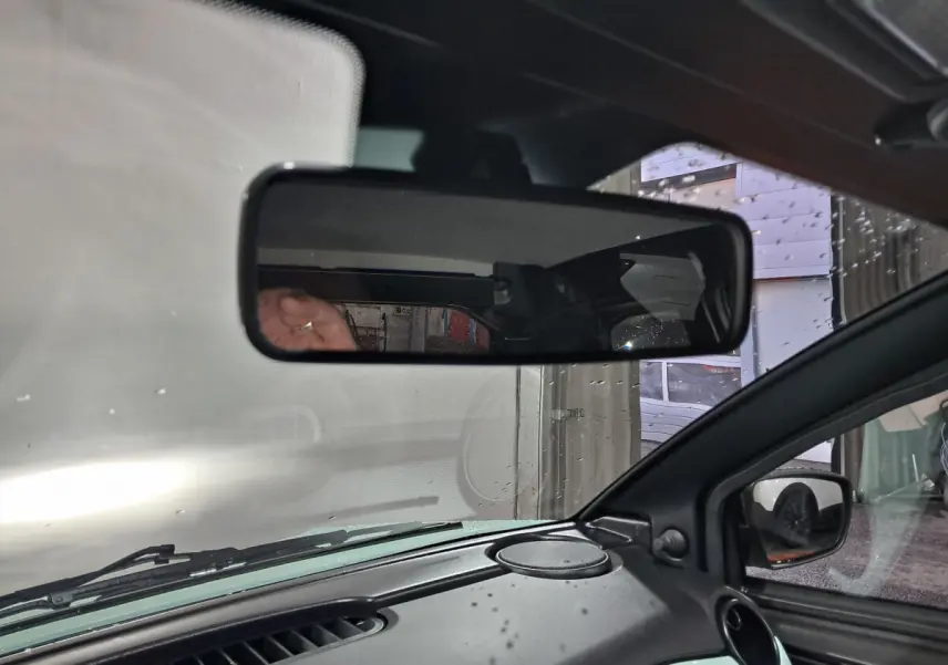 Vue intérieure du rétroviseur central et du tableau de bord d'une Aixam Minauto E chic 2025 en vert électrique.