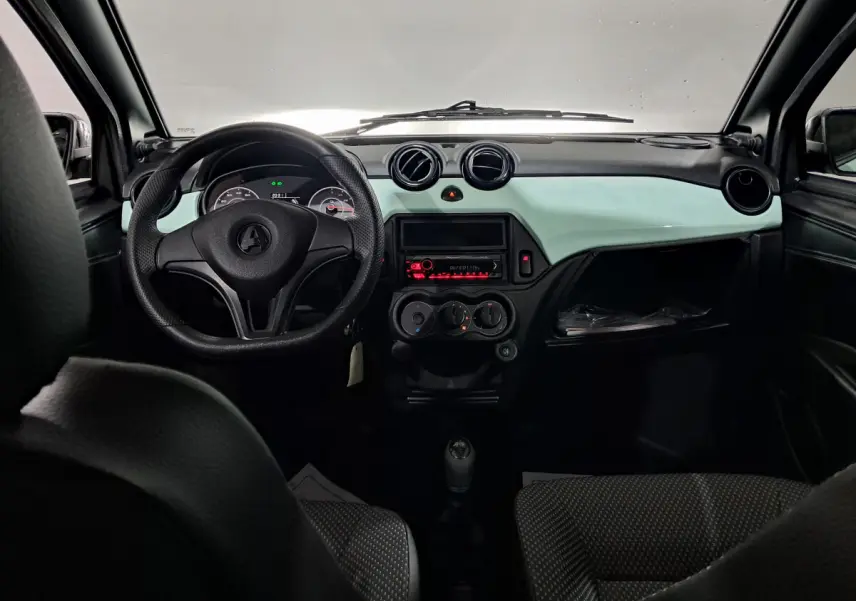 Vue intérieure avant de l'AIXAM MINAUTO E chic 2025, tableau de bord vert clair avec volant noir et commandes centrales.