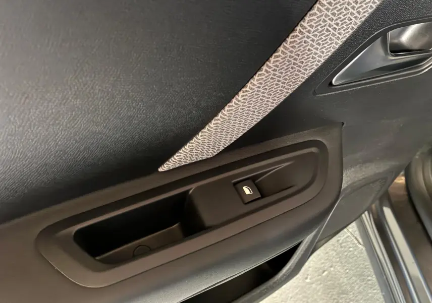 Gros plan sur la commande de lève-vitre côté gauche de la porte intérieure d’une Citroën C4 X gris 2024.