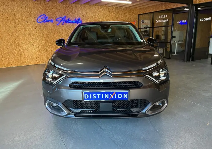 Vue frontale d'une Citroën C4 X gris métallisé 2024, avec calandre distinctive et éclairage LED moderne.