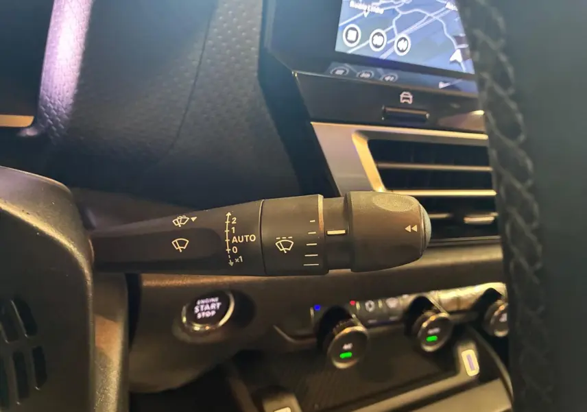 Gros plan sur la commande d’essuie-glace à gauche du volant dans l’habitacle gris-noir du Citroën C4 X 2024.