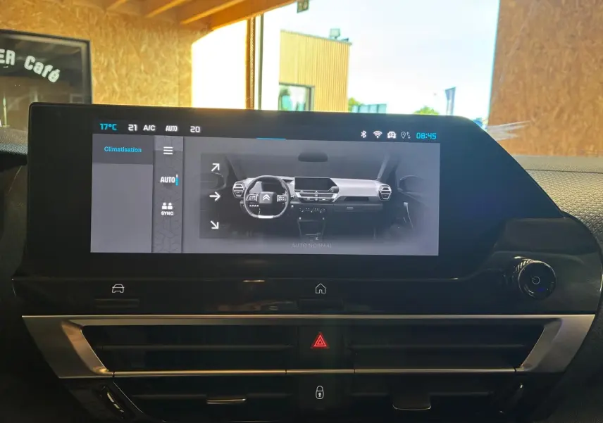Vue rapprochée de l’écran tactile central du tableau de bord du Citroën C4 X gris, affichant les réglages de climatisation.