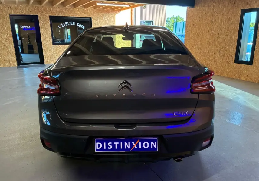 Vue arrière d'une Citroën C4 X gris foncé 2024, avec feux arrière LED et logo distinctif sur le hayon.