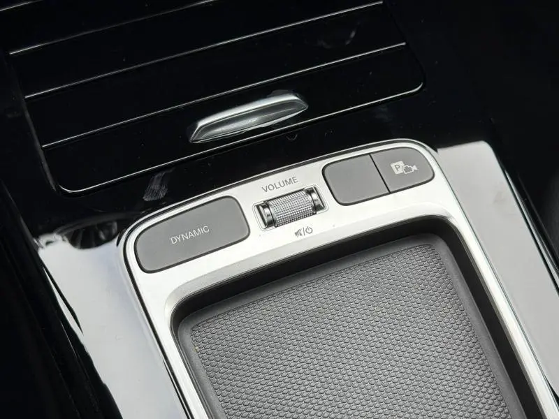 Gros plan sur la console centrale noire et argentée avec molette volume et boutons Dynamic et caméra de recul de la Mercedes Classe A AMG Line.