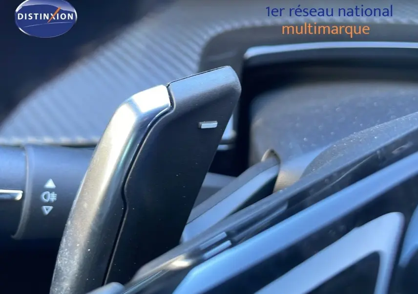 Le levier de commande au volant d'une Peugeot 508 SW noire, avec détails du tableau de bord en arrière-plan.