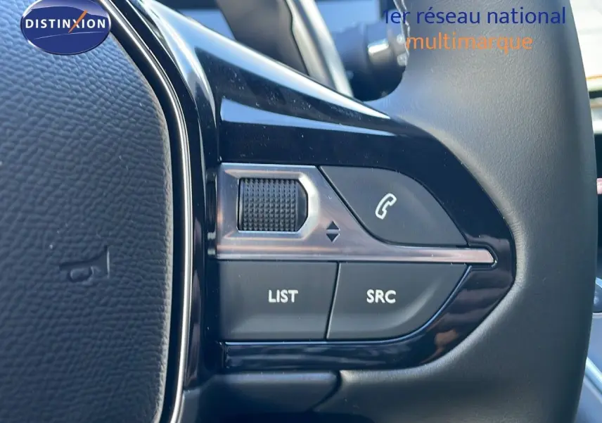 Gros plan sur les commandes du volant noir de la Peugeot 508 SW 2024, avec boutons list et appel.
