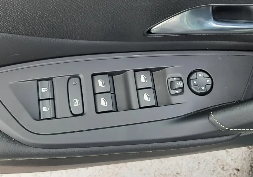Panneau de commandes des vitres et rétroviseurs côté gauche intérieur d'une Peugeot 308 Bleu Lagoa 2025.