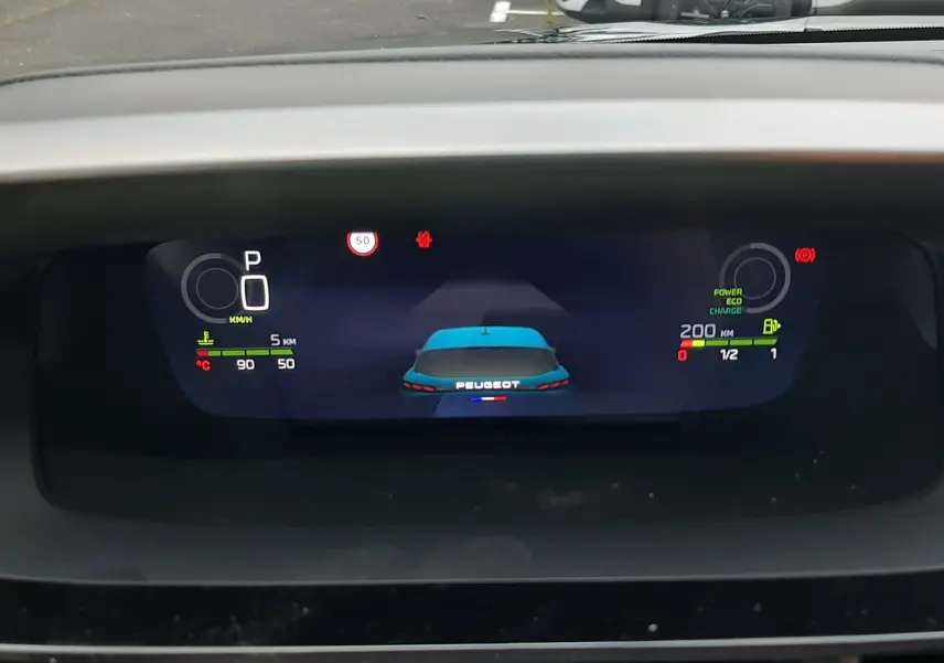 Affichage numérique du tableau de bord d'une Peugeot 308 hybride 2025 montrant l'arrière bleu Lagoa du véhicule en vue centrale.