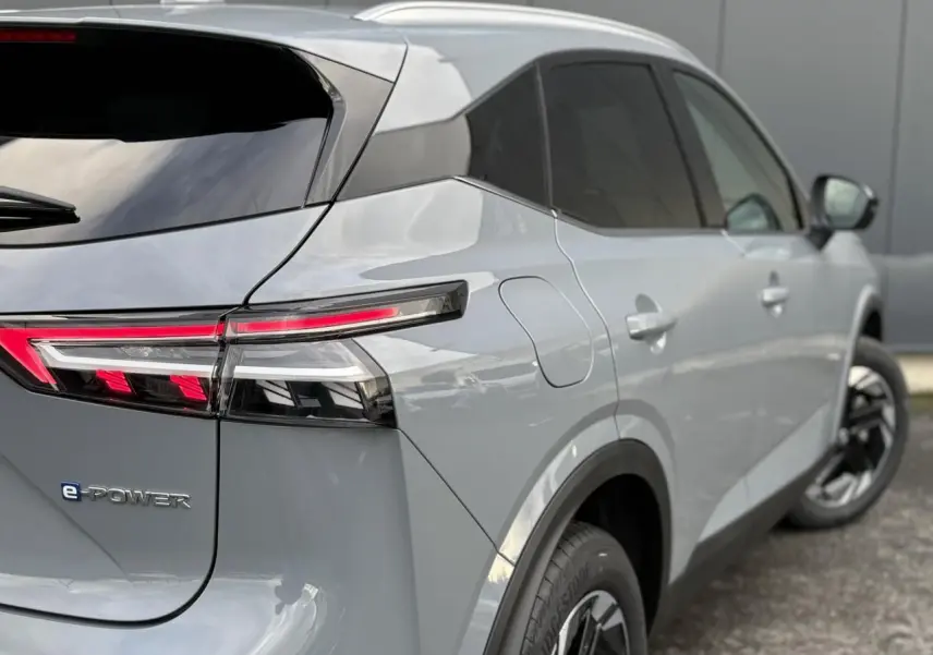 Vue 3/4 arrière droite du Nissan Qashqai gris Ceramic avec feux arrière LED et badge e-POWER visible.