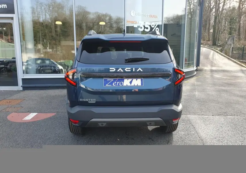 Vue arrière du Dacia Bigster bleu indigo avec feux LED en forme de C et logo DACIA bien visible.