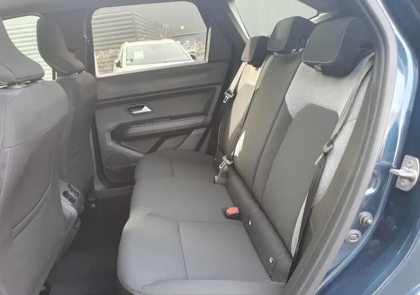 Vue intérieure arrière côté droit du Dacia Bigster bleu indigo, montrant la banquette 3 places avec ceintures et appuie-têtes.