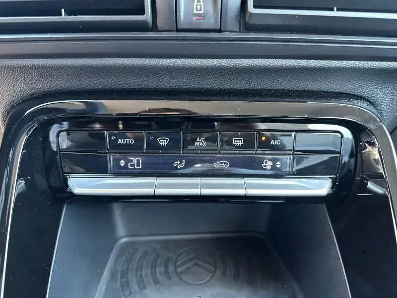 Détail du tableau de commande de climatisation automatique sur Citroën C3 noire, affichant 20°C et fonctions A/C activées.