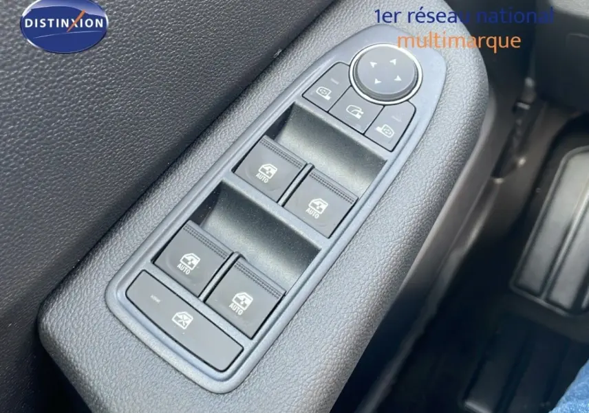 Gros plan sur les commandes des vitres électriques côté conducteur d’une Renault Clio Evolution Blue dCi 100, intérieur noir.