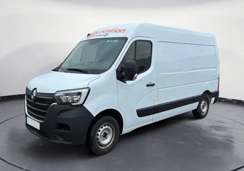 Vue 3/4 avant droit d’un Renault Master blanc 2024 utilitaire avec marquage "location" sur le toit.