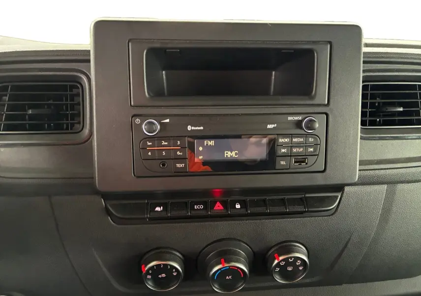 Tableau de bord du Renault Master 2024 avec radio Bluetooth, commandes climatisation manuelle et boutons fonctionnels en vue frontale.