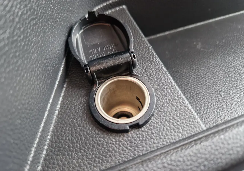 Prise allume-cigare ouverte en gros plan sur la console intérieure noire du Renault Master L2H2 blanc 2024.