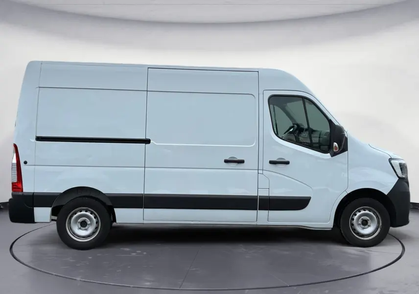 Vue latérale droite d’un utilitaire blanc Renault Master L2H2 2024 avec bandeau noir et roues acier simples.