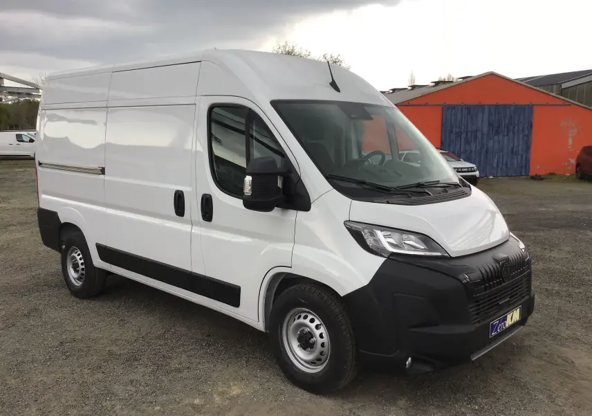 Vue 3/4 avant droit d'un Peugeot Boxer Fourgon blanc 2025 avec pare-chocs noir et jantes acier.