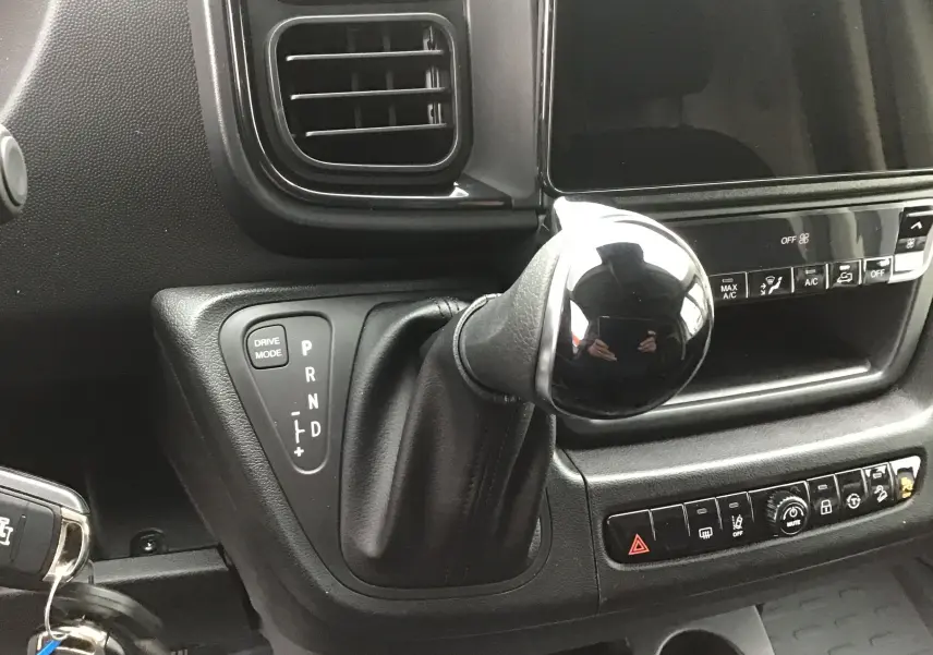 Gros plan sur le levier de vitesses automatique noir et la console centrale du Peugeot Boxer Fourgon blanc 2025.