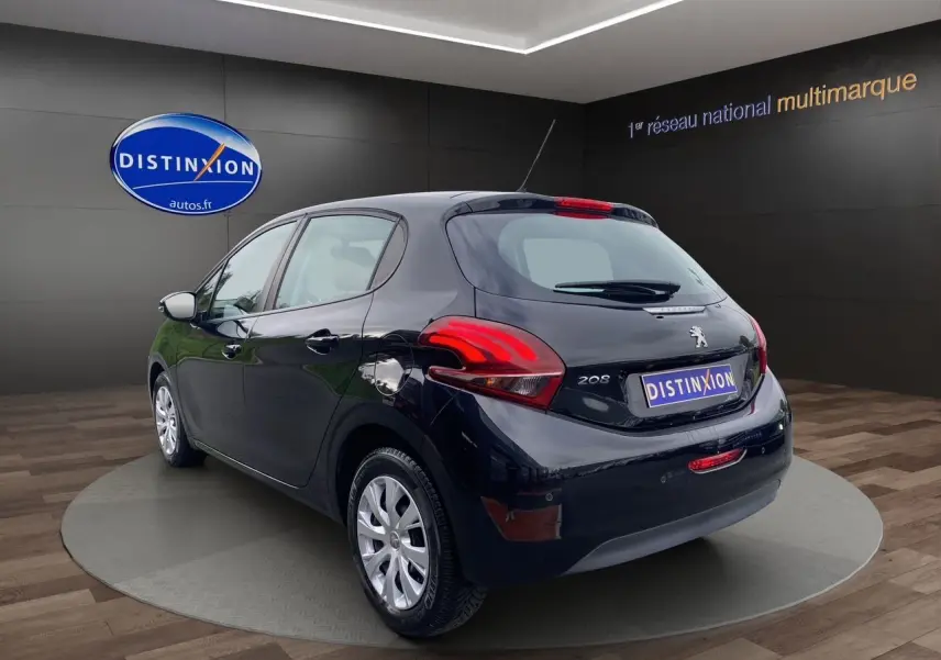 Vue 3/4 arrière droite d'une Peugeot 208 Affaire Premium Pack noire de 2019 avec radar de recul en showroom.
