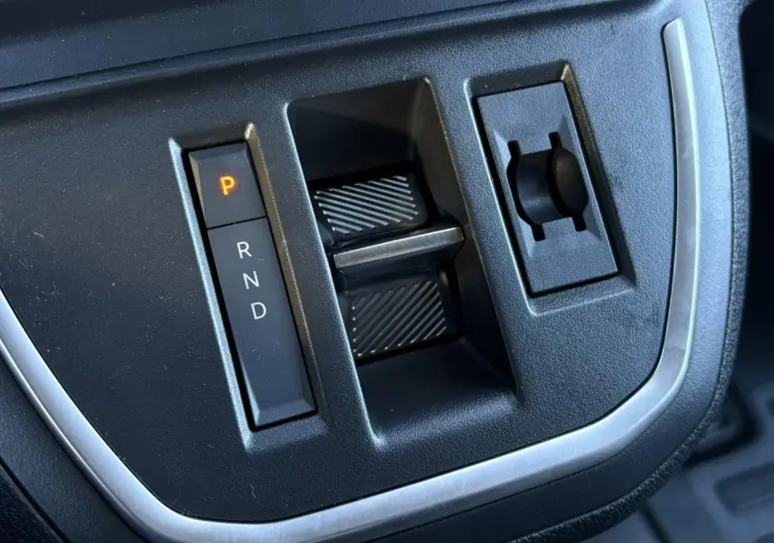 Gros plan sur la commande de boîte automatique noire du Citroën Jumpy XL gris Titane, avec levier en position parking.