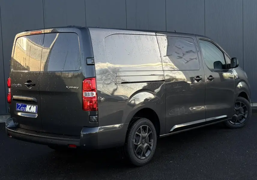Vue 3/4 arrière droite d'un Citroën Jumpy XL gris titane avec pack look et jantes noires mate.