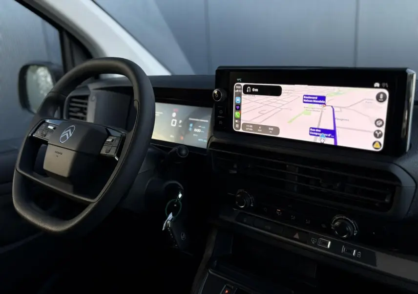 Vue intérieure côté conducteur du Citroën Jumpy gris avec écran GPS tactile et volant multifonction noir.