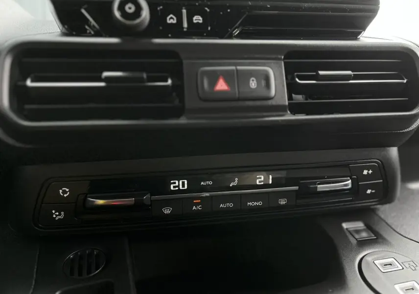 Gros plan sur la console centrale noire du Citroën Berlingo Multispace, affichant la climatisation automatique bi-zone.