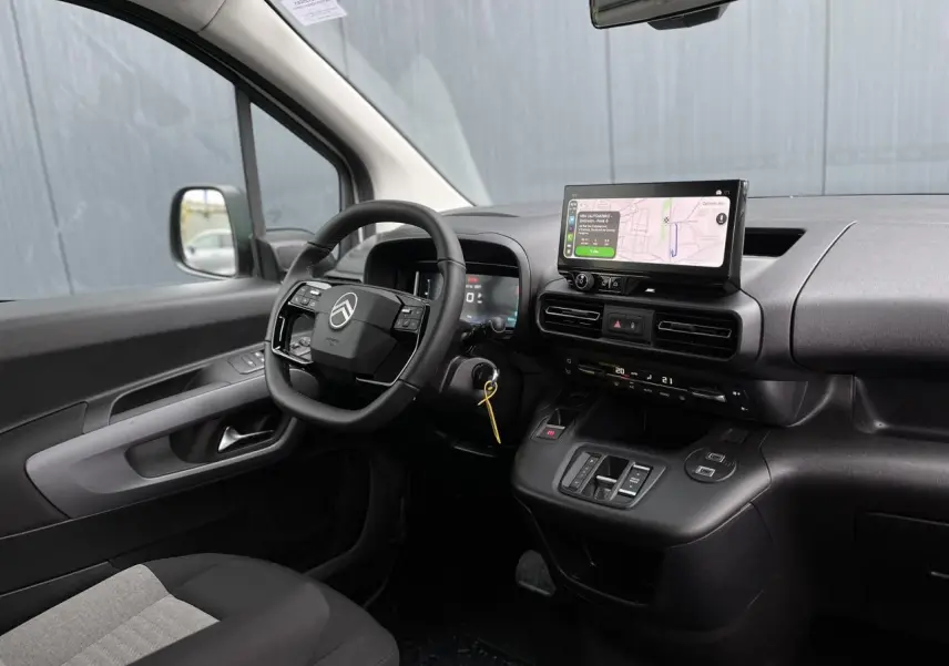 Vue intérieure côté conducteur du Citroën Berlingo Multispace 2025 avec tableau de bord noir et écran tactile GPS.