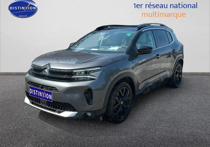 SUV Citroën C5 Aircross gris platinium en 3/4 avant droit avec jantes noires et barres de toit visibles.