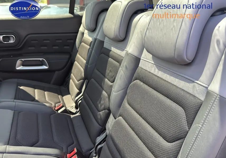 Vue rapprochée des trois sièges individuels arrière en tissu brun et cuir noir du Citroën C5 Aircross 2024.