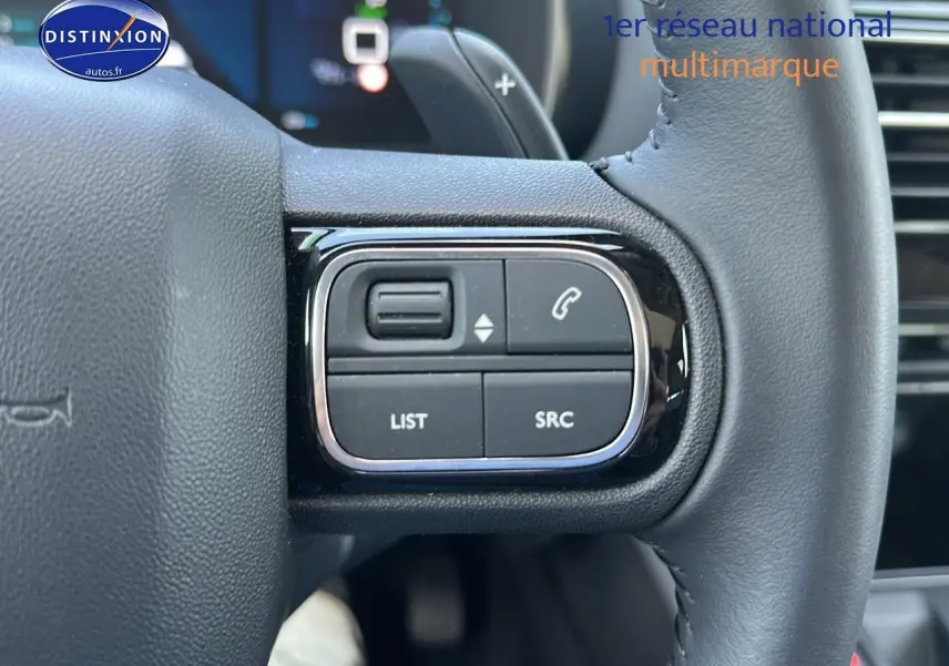Gros plan sur les commandes gauche du volant cuir du Citroën C5 Aircross gris platinium 2024 hybride rechargeable.