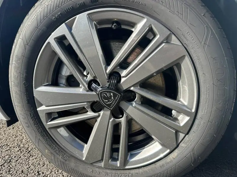 Gros plan sur la jante alu grise de la Peugeot 308 Bleu Obsession 2025 avec logo Peugeot central noir.