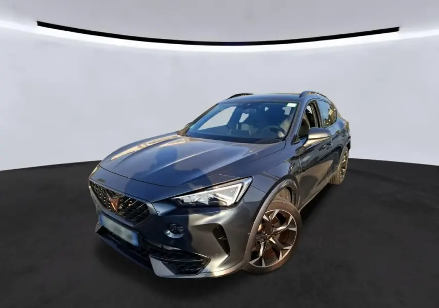 Vue 3/4 avant droite d'une CUPRA Formentor gris foncé 2023 avec jantes alliage et calandre marquée du logo Cupra.
