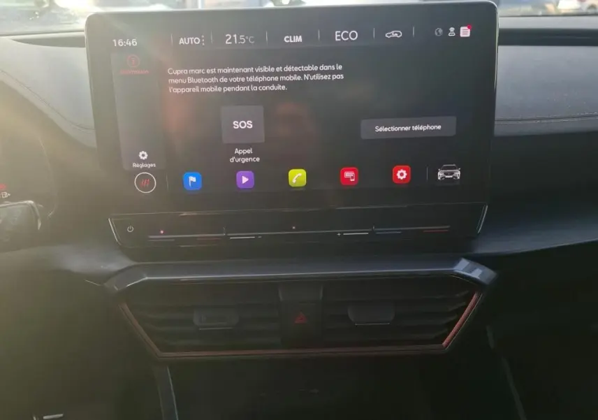 Écran tactile central allumé du tableau de bord d'un CUPRA Formentor gris foncé, affichant le menu Bluetooth et les réglages climatiques.