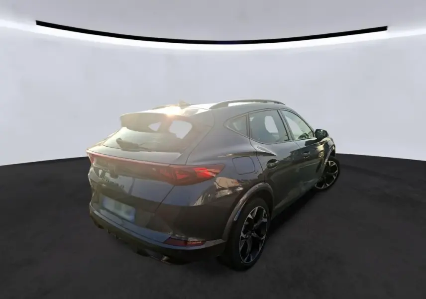 Vue 3/4 arrière droite d'un CUPRA Formentor gris foncé 2023, hybride rechargeable, avec jantes noires et toit ouvrant.
