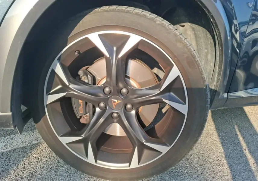 Gros plan sur la roue avant droite gris foncé d'une CUPRA Formentor 1.4 E-HYBRID 245 DSG6 avec jante noire et argentée.