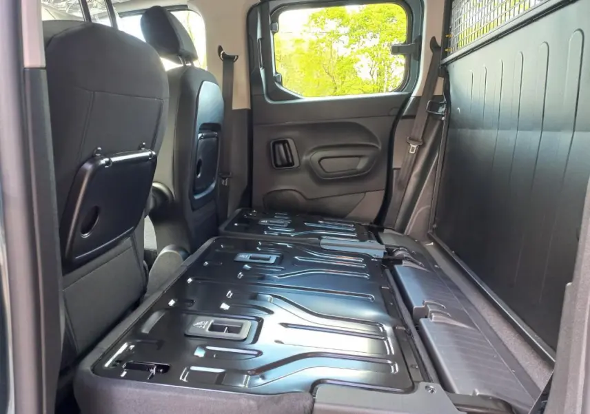 Vue intérieure côté droit du coffre d’un Opel Combo Life Elegance M 2025 bleu avec banquette arrière rabattue et espace de chargement plat.