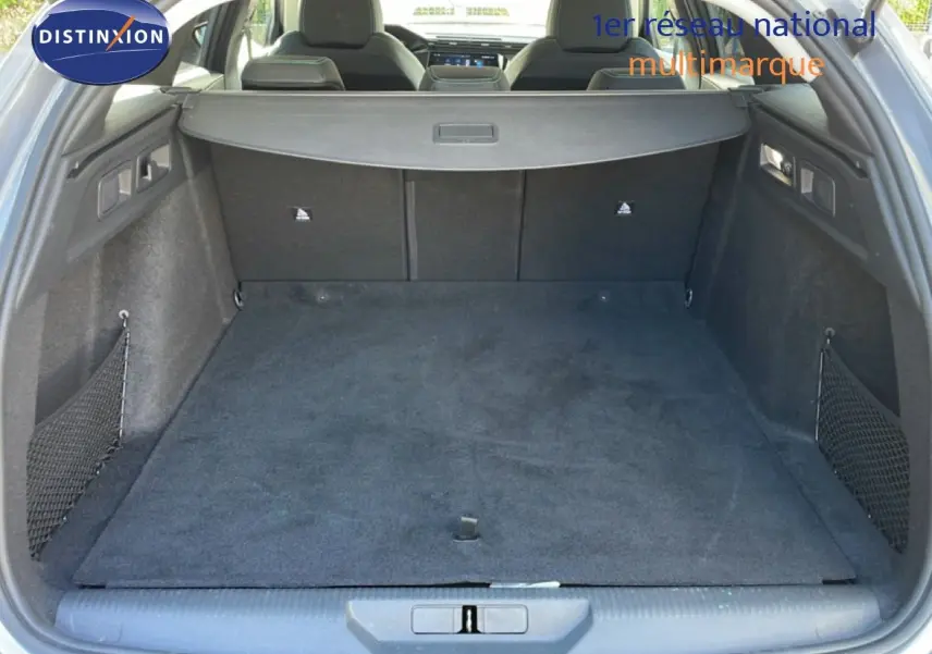 Coffre ouvert vu de l'arrière d'une Peugeot 308 SW gris Artense, montrant un espace de chargement propre et bien agencé.