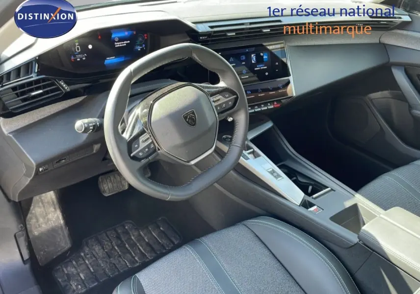 Vue intérieure du poste de conduite de la Peugeot 308 SW gris Artense, avec volant multifonction et écran tactile central.