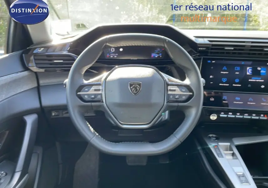 Vue intérieure centrée sur le volant cuir noir et le tableau de bord numérique d'une Peugeot 308 SW 2025.