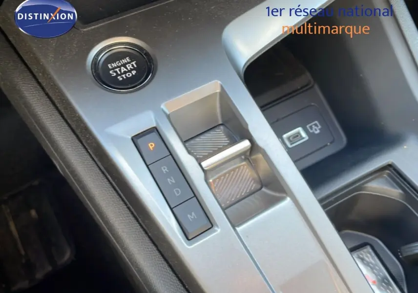 Gros plan sur la console centrale grise du Peugeot 308 SW Hybrid 2025, montrant le bouton start/stop et la commande de boîte automatique.