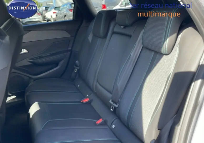Vue intérieure sur la banquette arrière en tissu et cuir gris noir avec surpiqûres bleues d'une Peugeot 308 SW 2025.